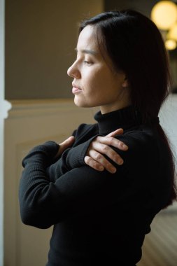 Siyah ile çapraz kol ayakta ve aşağı bakıyor kapalı karışık ırk genç güzel model portresi giymiş 