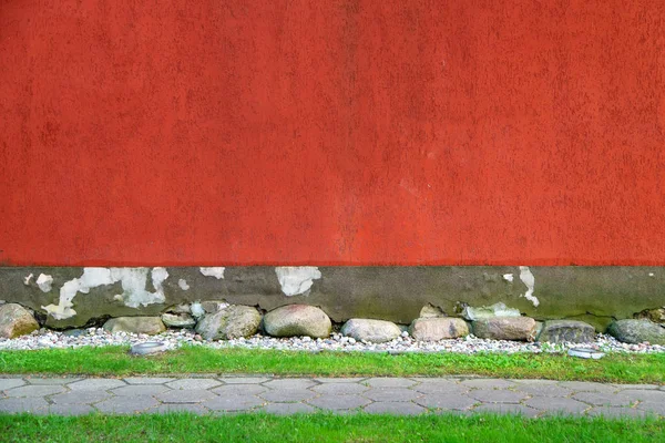 Old painted red wall and trail with grass