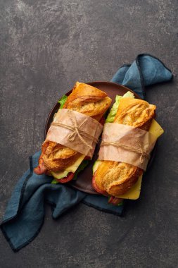 Pastırmalı ve peynirli baget sandviç ve tekstilde sebzeli marul. 