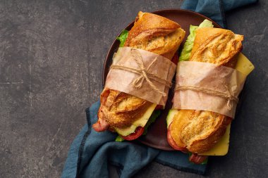 Pastırmalı ve peynirli baget sandviç ve tekstilde sebzeli marul. 