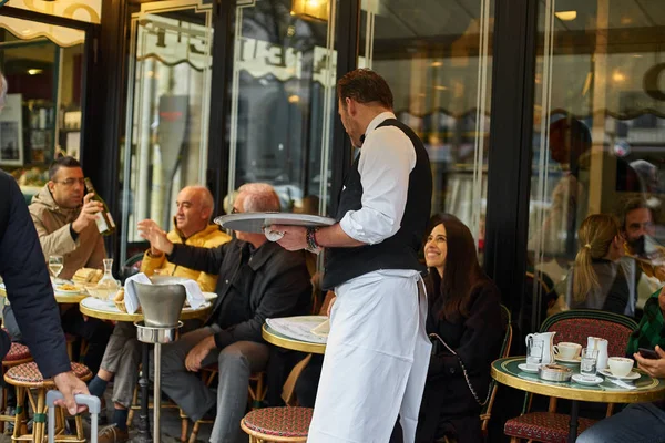 Paris, Fransa - 10 Kasım 2019: Paris Kafe 'de müşterilere kahve servisi yapan garson 