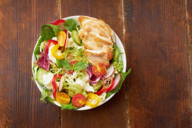 Domatesli taze salata ve dolma biberli tavuk ve ahşap arka planda mozzarella peynirli turp.  