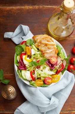 Domatesli taze salata ve dolma biberli tavuk ve ahşap arka planda mozzarella peynirli turp.  