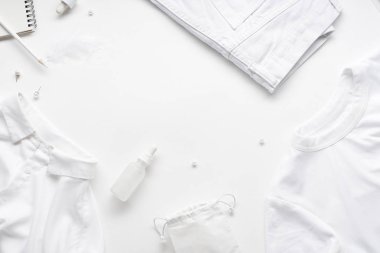 Beyaz monokromatik daire, beyaz arka planda giysi ve aksesuarlı kırtasiye malzemeleri ve güzellik ekipmanları vardı. Günlük tasarımı kavramı