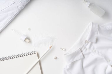 Beyaz monokromatik daire, beyaz arka planda giysi ve aksesuarlı kırtasiye malzemeleri ve güzellik ekipmanları vardı. Günlük tasarımı kavramı