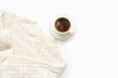 coffee in white cup with warm knitted sweater isolated on white background, close-up 