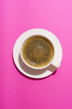 coffee in white cup on purple background, close view 