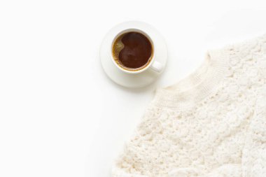coffee in white cup with warm knitted sweater isolated on white background, close-up 