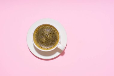 coffee in white cup on pink background, close view 