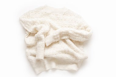  Warm knitted sweater on white background. Minimalistic flat lay                              