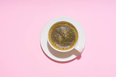 coffee in white cup on pink background, close view 