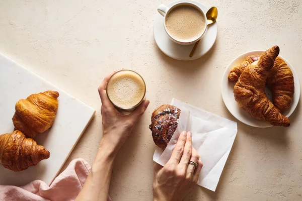 Kvinnliga Händer Håller Kopp Cappuccino Och Bulle Bordet Nära Croissanter — Stockfoto