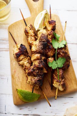 Limonlu tavuk tikka kebabı. Geleneksel Hint yemeği yoğurt ve beyaz ahşap arka planda baharatlarla marine edilmiş tavuktan yapılır..