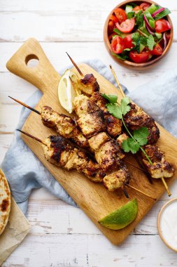 Kırmızı soğanlı tavuk tikka kebabı ve taze salata. Geleneksel Hint yemeği yoğurt ve beyaz ahşap arka planda baharatlarla marine edilmiş tavuktan yapılır..