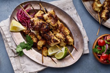 Salamura soğanlı tavuk tikka kebabı ve taze salata. Geleneksel Hint mutfağı konsepti, lezzetli başlangıç. 