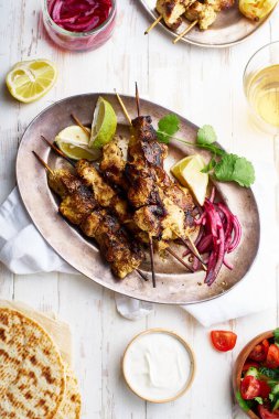Kırmızı soğanlı tavuk tikka kebabı ve taze salata. Geleneksel Hint yemeği yoğurt ve beyaz ahşap arka planda baharatlarla marine edilmiş tavuktan yapılır..
