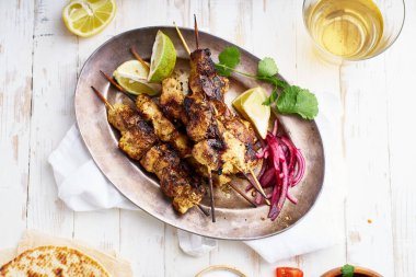 Kırmızı soğanlı tavuk tikka kebabı ve taze salata. Geleneksel Hint yemeği yoğurt ve beyaz ahşap arka planda baharatlarla marine edilmiş tavuktan yapılır..