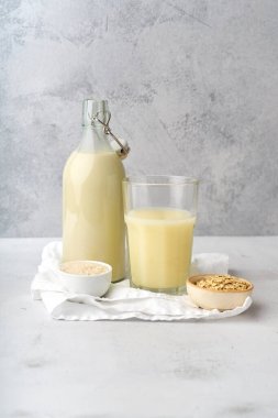 Şişede pirinç sütü ve yulaf sütü ve mısır gevreğiyle bardaklar ve kaseler laktoz intoleransı için sağlıklı süt alternatifi. 