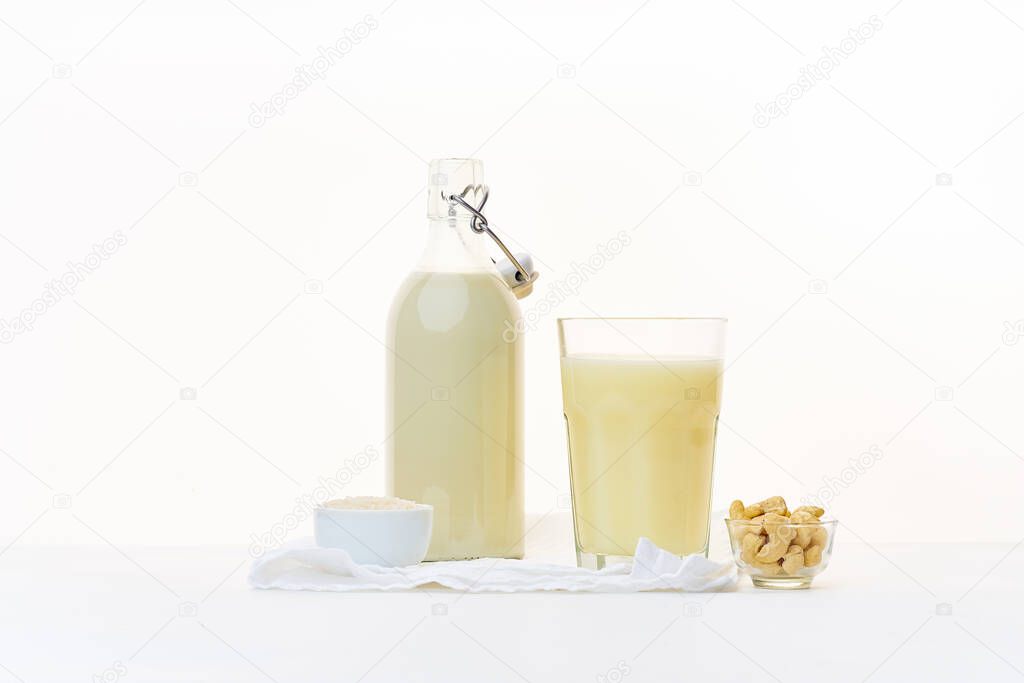 Rice milk and cashew milk in bottle and cup and bowls with cereals, Healthy dairy alternative for lactose intolerance concept 