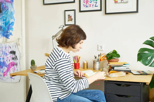 Artystka Pracująca Domu Młoda Kobieta Ubrana Dżinsy Koszulę Paski Siedząca — Zdjęcie stockowe