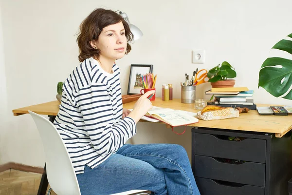 Artystka Pracująca Domu Kobieta Ubrana Dżinsy Koszulę Paski Siedząca Przy — Zdjęcie stockowe