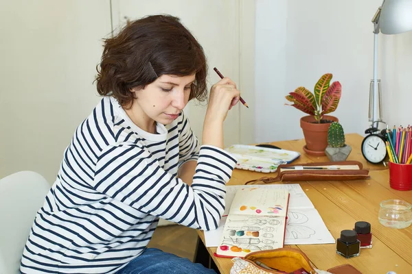 Artystka Pracująca Domu Kobieta Ubrana Dżinsy Koszulę Paski Siedzi Przy — Zdjęcie stockowe