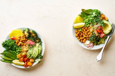 Avokado ve nohutlu sağlıklı vejetaryen yemek kaseleri kinoalı nohut ve mikro yeşillikle süslenmiş sebzeler ve taş zeminde fındık sosu.