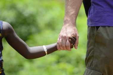 Yetişkin el Afrikalı çocuk elini tutarak