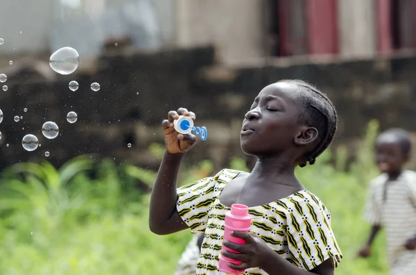 Afrikaanse meisje zeepbellen blazen — Stockfoto