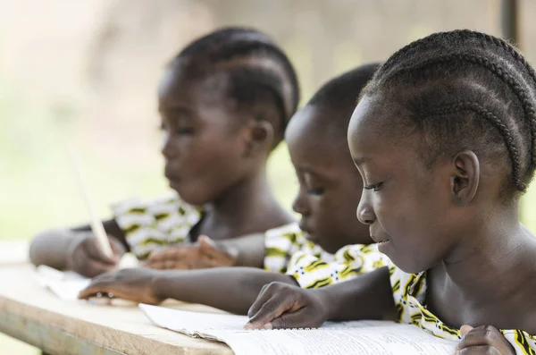 Two girls and boy reading and writing