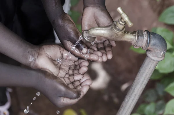 Handen van Afrikaanse kinderen onder kraan — Stockfoto