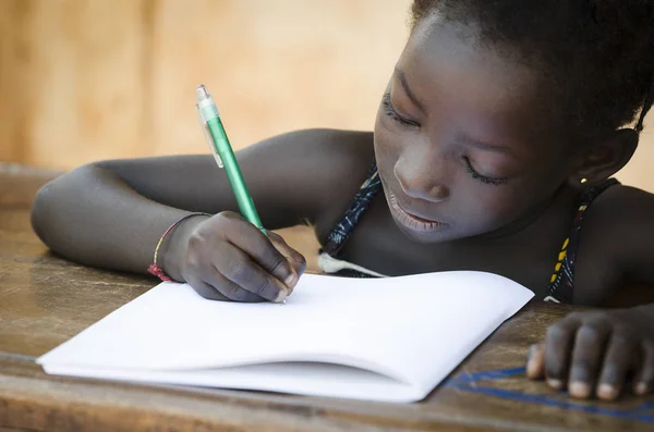 Linda chica africana escribiendo en la escuela — Foto de Stock