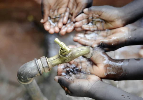 Mains d'enfants africains sous robinet — Photo