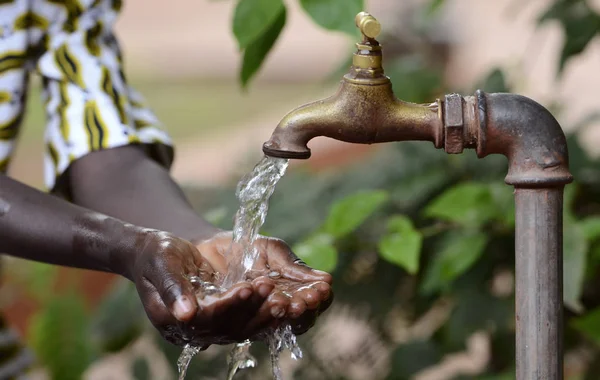 Handen van Afrikaanse kind vol water — Stockfoto