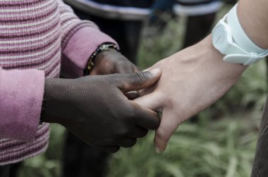 Afrikalı Çocuk yetişkin beyaz elini tutarak