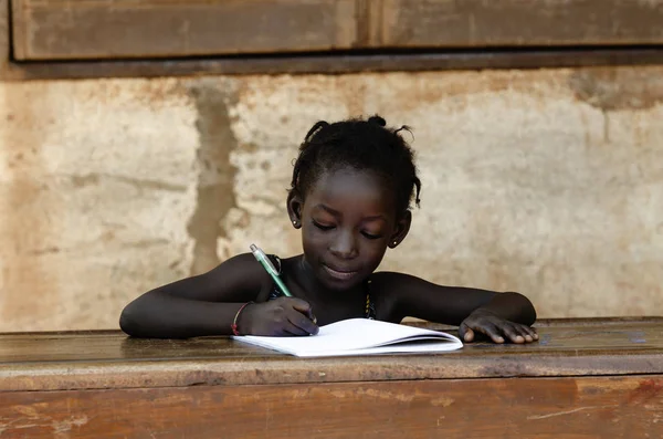 Young girl sitting and writing on paper