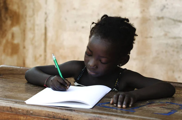 Chica joven sentada y escribiendo en papel — Foto de Stock