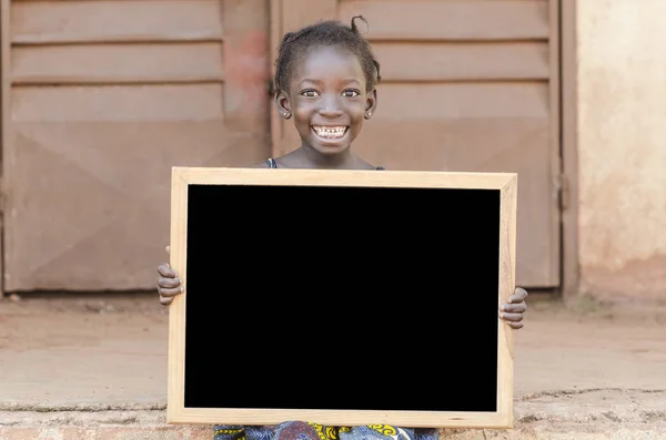 Chica sosteniendo el letrero y mirando a la cámara — Foto de Stock