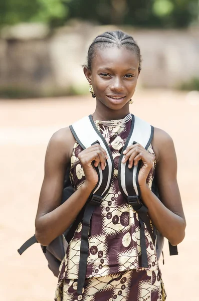 Chica joven con mochila mirando a la cámara — Foto de Stock