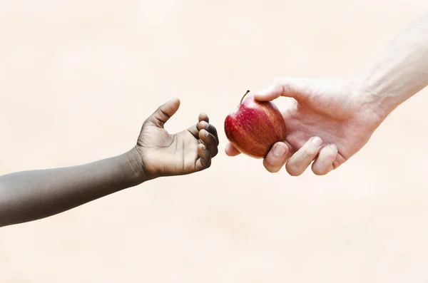 Main donnant pomme à la main de l'enfant — Photo