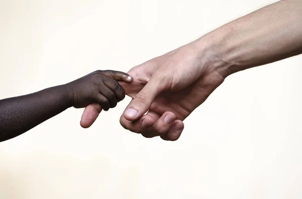 African hand holding adult caucasian finger — Stock Photo, Image