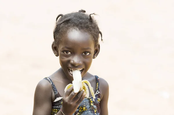 Afrikaanse meisje eten van banaan — Stockfoto