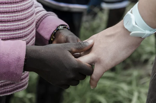 Criança africana segurando mão caucasiana adulta — Fotografia de Stock