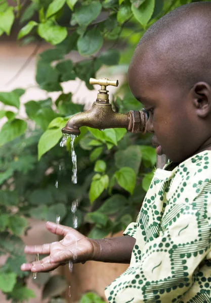 Afrikaanse kind en water kraan — Stockfoto