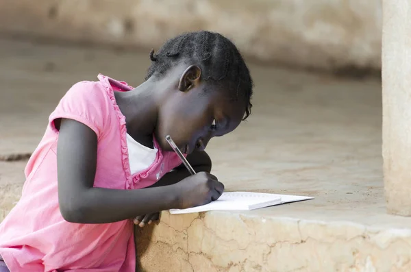 Jeune fille assise et écrivant sur papier — Photo