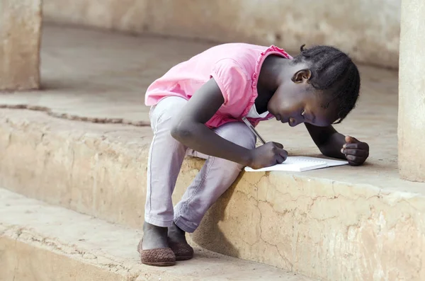 Jeune fille assise et écrivant sur papier — Photo