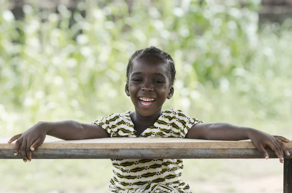 Chica sentada y sonriendo a la cámara — Foto de Stock