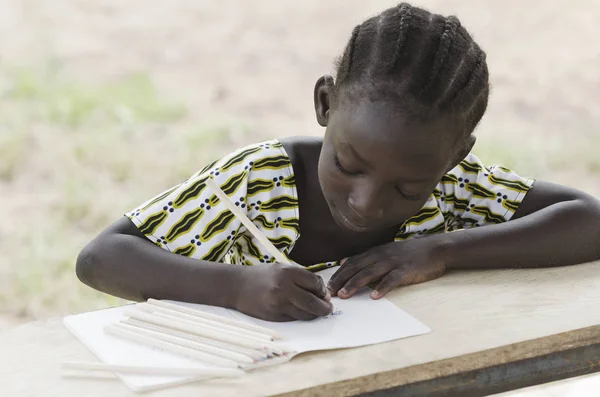 Chica joven sentada y escribiendo en papel — Foto de Stock