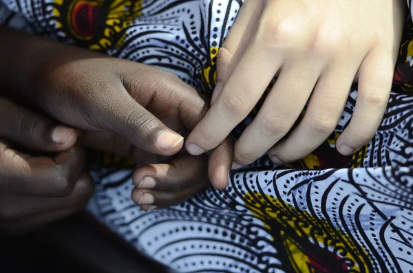 Kaukasische hand met Afrikaanse kind hand — Stockfoto