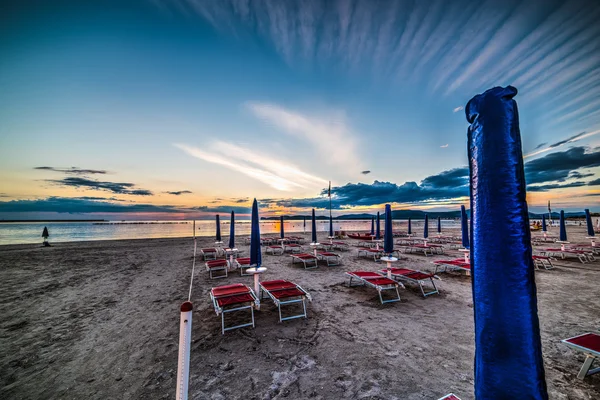 Sandalye ve şemsiye gün batımında deniz — Stok fotoğraf